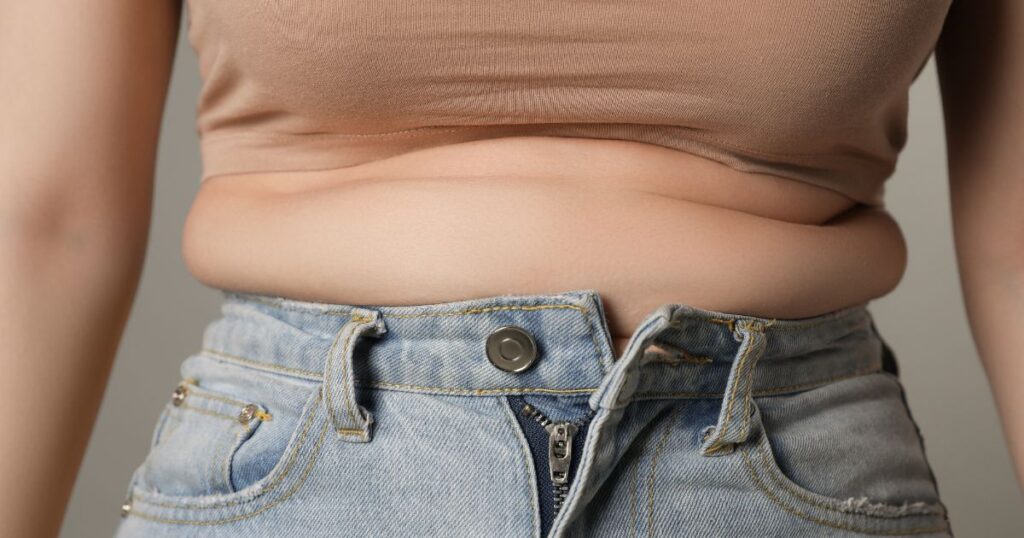 Woman experiencing belly fat during perimenopause despite eating healthy.

